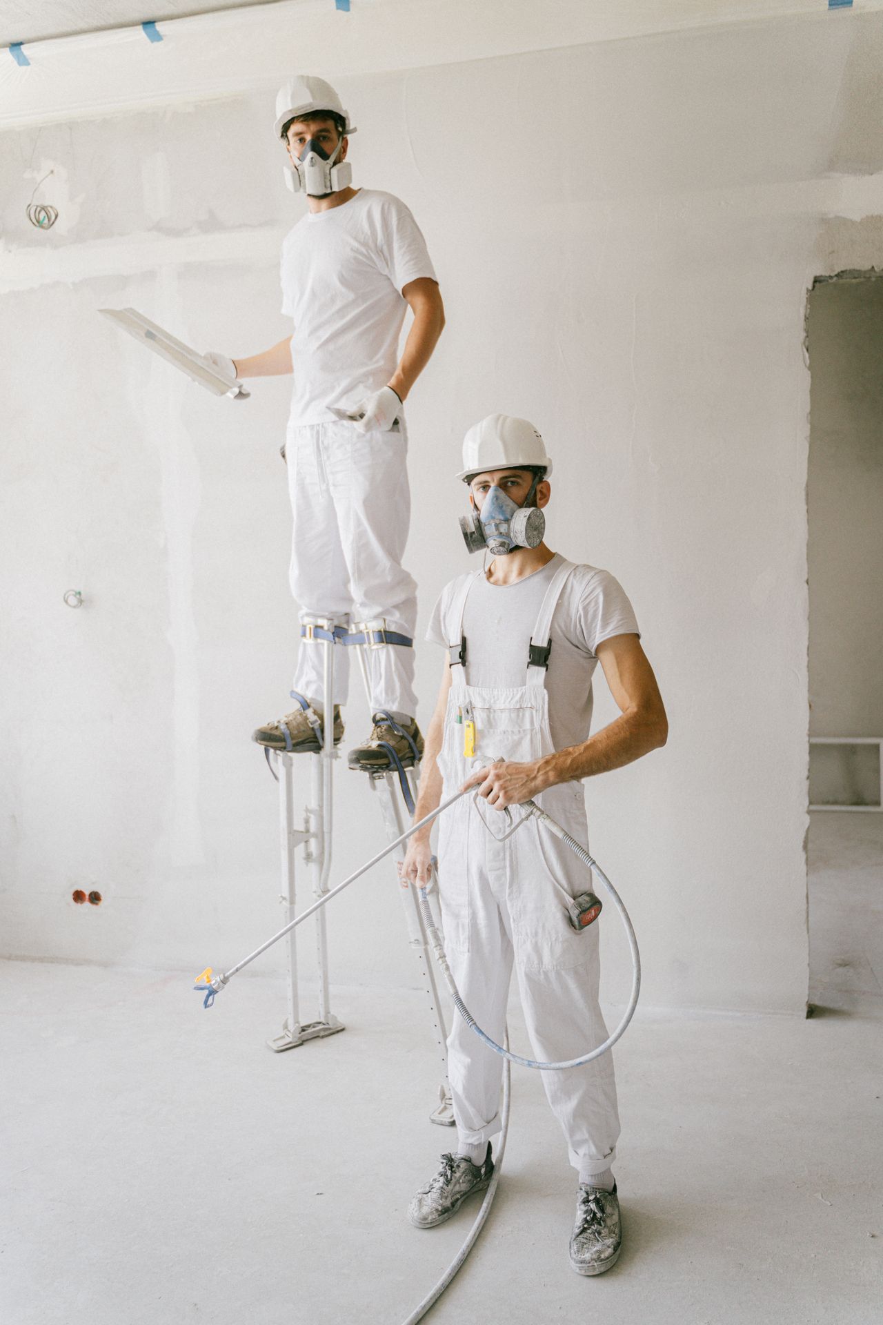 Drywall finisher on stilts working a ceiling seam — marketing for remodeling companies
